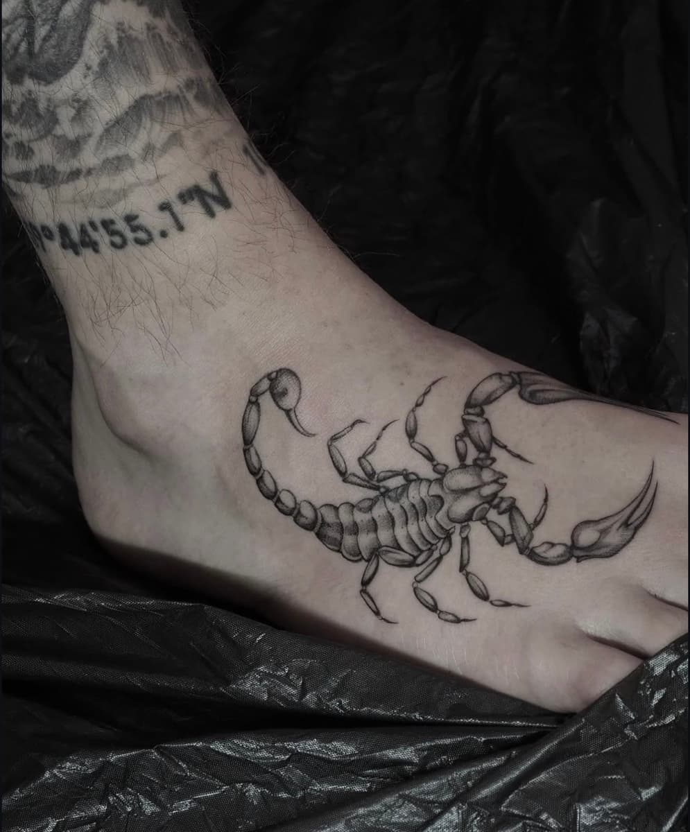 Black and grey oni mask tattoo with red eyes on the upper chest