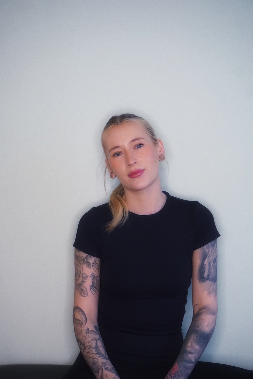 Woman with blonde hair standing against a wall